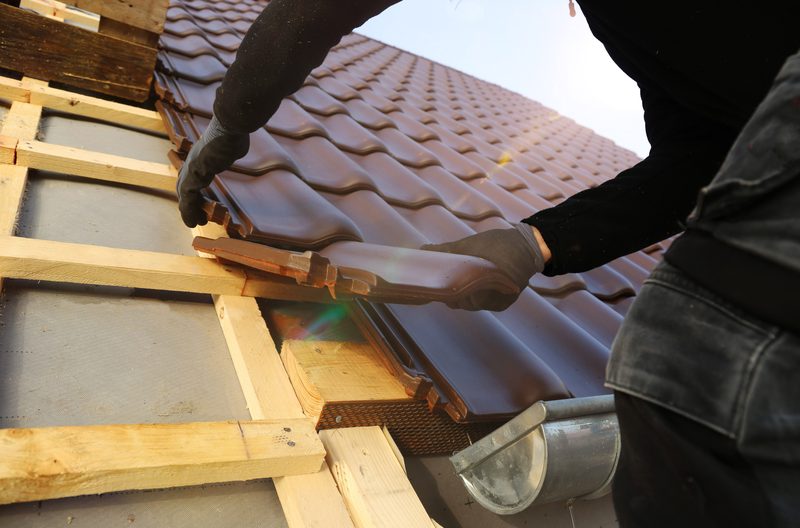 Rénovation de tuiles sur une toiture ancienne